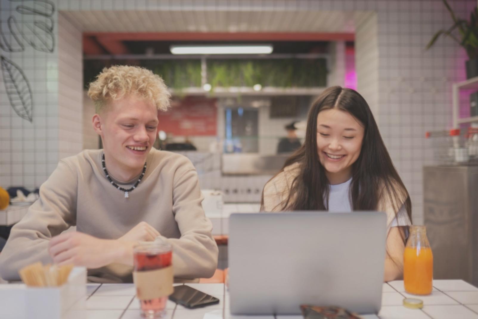 Students working on financial analysis with multiple monitors showing data charts and Taiwan market information